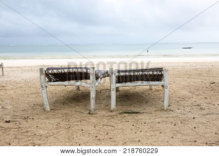 Beach with sun loungers and a place for rest at sunset.