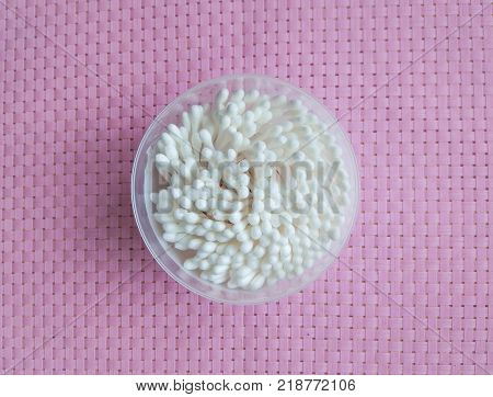 Cotton Swabs In Plastic Jar On Pink Wicker Background