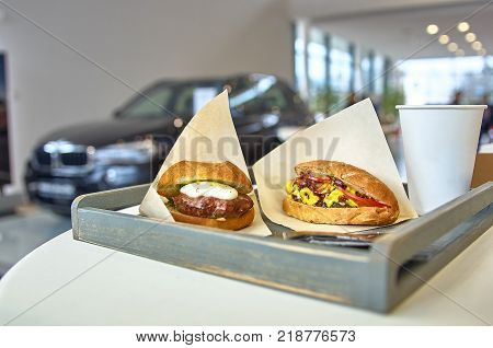 Prepare delicious burger with fried meat cutlet placed on a table in wooden tray, diagonally placed. In the showroom.