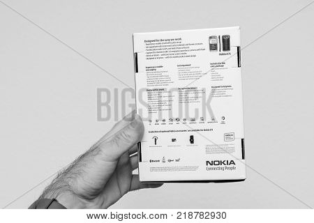PARIS FRANCE - DEC 18 2017: Man holding against white background vintage and luxury NOKIA box of a E71 smartphone with specification technical details