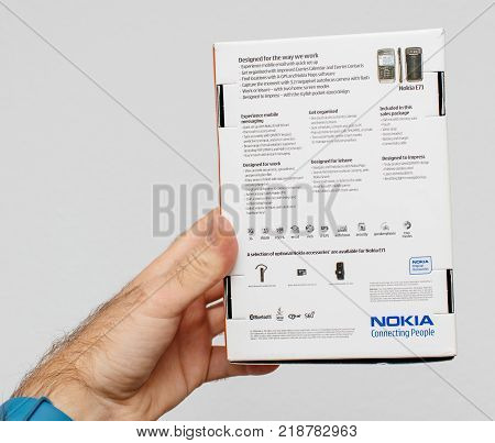 PARIS FRANCE - DEC 18 2017: Man holding against white background vintage and luxury NOKIA box of a E71 smartphone with specification technical details