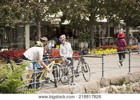 Italian People And Foreigner Travelers Stop Bicycle And Walking On The Footpath At Riverside Of Pass