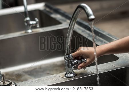 Children use their hands to open the faucet Water shortage concept.