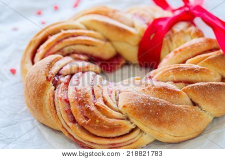 Raspberry jam swirl brioche wreath on a wooden background.