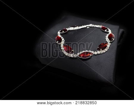 Jewellery silver ruby diamonds bracelet isolated on black cloth background