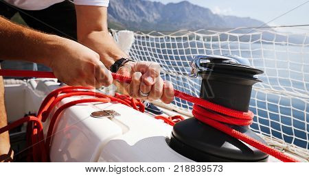 Young strong beautiful woman sailing the boat