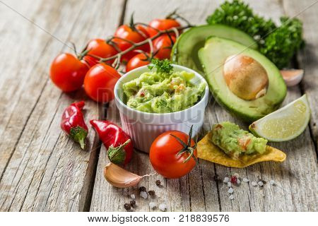 Guacamole sauce and indredients on wood background, copy space