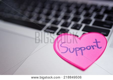 Paper red heart on laptop,charity,support and helping concept.