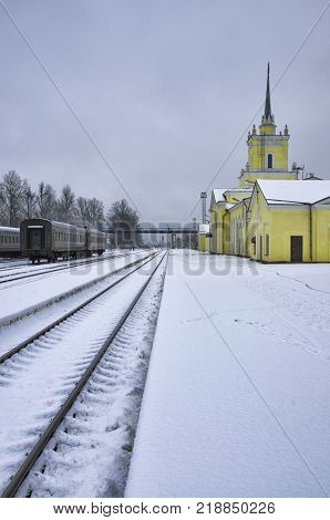 Deserted platform and railway station in the winter evening. City of Dno Pskov Oblast Russia