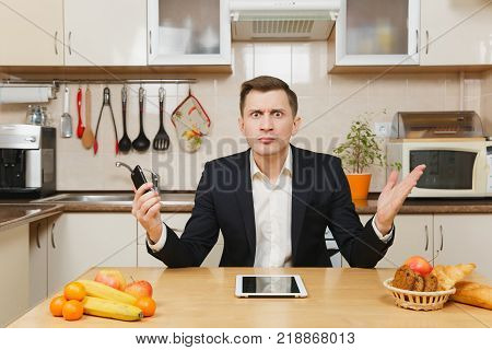 Perturbed Young Business Man In Suit, Shirt, Having Breakfast, Sitting At Table With Tablet, Spreadi