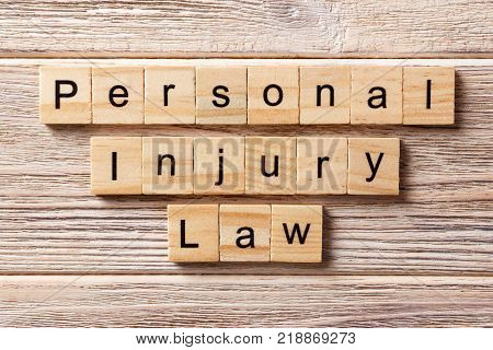 personal injury law word written on wood block. personal injury law text on table concept.