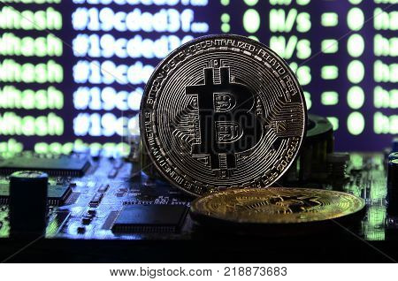 The digital process of cryptocurrency mining by using the GPUs. Bitcoins and video card on a working display and mining screen