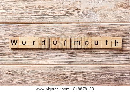 Word of Mouth word written on wood block. Word of Mouth text on table concept.