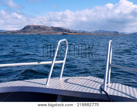 Fishing boat with fishing rods floating in open sea. Background beautiful sky. Sport sea fishing