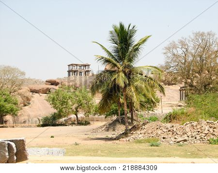 View of ancient ruins on Hemakuta hill in Hampi, Karnataka, India. Landscape with unique mountain formation with amazing stones, tropical nature and temple. UNESCO World Heritage Site