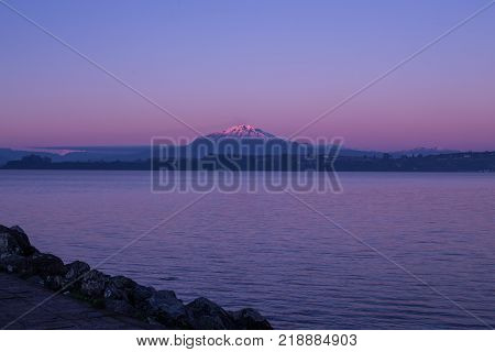 Volcano and lake in sunset in city