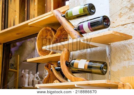 Decorative wooden holder handmade with bottles of white and red Greek wine. Unique Souvenirs from the old resort town Rethymno in Greece. Culture and Mediterranean cuisine on island Crete