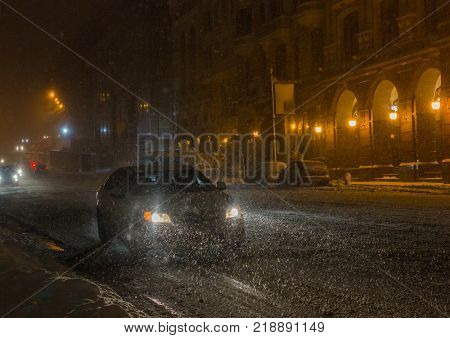 Street with traffic at blizzard evening. Winter, snow city car. Kiev, Ukraine