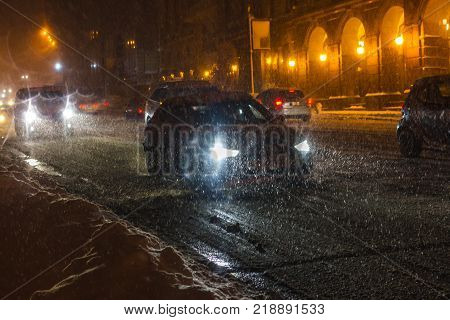 Street with traffic at blizzard evening. Winter, snow city car. Kiev, Ukraine