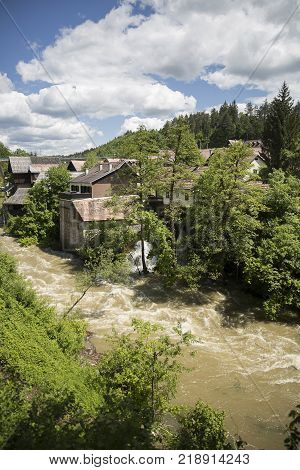 Croatian Village Of Rastoke By A River Canyon With Wooden Houses In A Green Landscape With Trees And