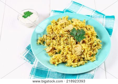 Indian biryani with chicken, yogurt and spices in a plate on a wooden table. New Year's, Christmas dish