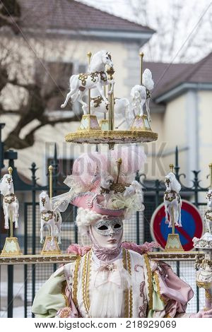 Annecy France February 23 2013: Image of a person in a complex disguise with horses posing in Annecy France during a Venetian Carnival which celebrates the beauty of the real Venice.