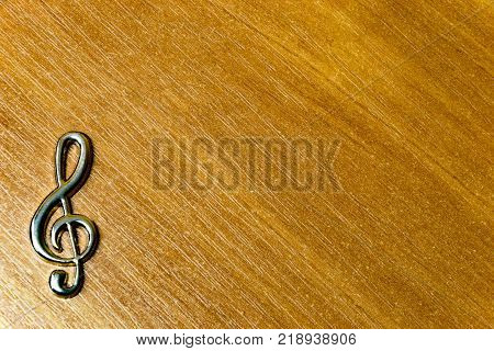 Metal Treble Clef Sign Isolated On Wood Background