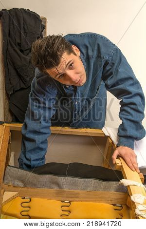 upholsterer padding a sofa with open framing in the upholsterer shop