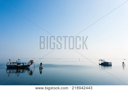 Fishing boats inside Po river lagoon Italy. Italian landscape. Minimal water panorama