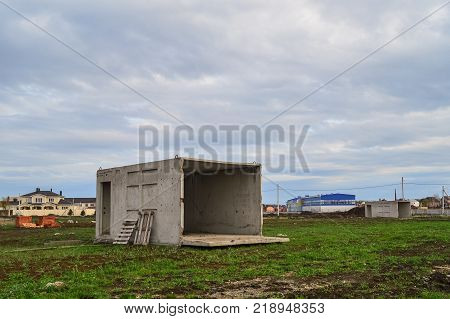 An abandoned concrete box in the field is used as a house.