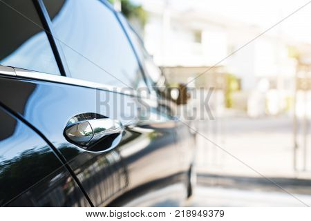 Black shiny surface of luxury modern car side view, selective focus
