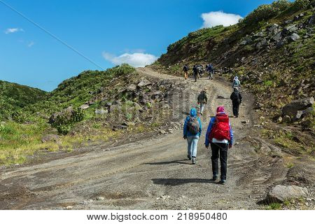 Kamchatka Peninsula, Russia - August 25, 2016: Group of tourists walks along the Viluchinsky pass