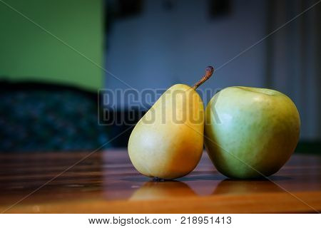 Fresh pear and apple on wooden table