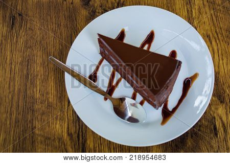 Delicious chocolate cake with spoon on white plate