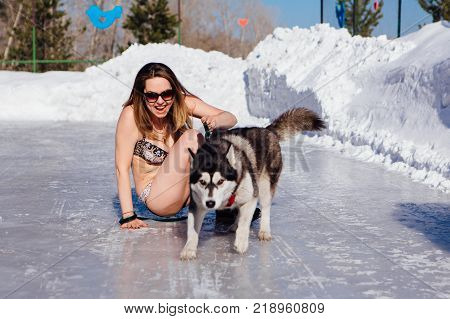 Novokuznetsk, Kemerovo region, Russia - 23 Feb, 2017 : White beaches of Siberia is an enterteiment activity where people playing beach games dressed in bikini in winter. Women in bikini with husky