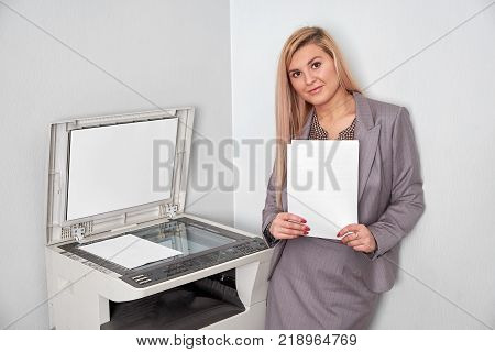 Businesswoman working on a copy machine at the office.