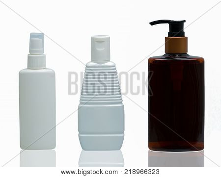 Three white and brown plastic cosmetic bottles with different type of cap : pump spray and cap isolated on the white background with blank label and copy space