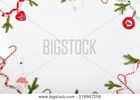 Christmas holiday composition. Festive creative red pattern, xmas handmade decor holiday with ribbon, candy canes, gift, christmas tree and decorations on white background. Flat lay, top view