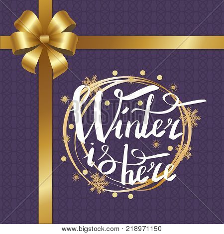 Winter is here calligraphic inscription written in round golden frame vector on purple background, xmas greeting message with gold ribbon and bow