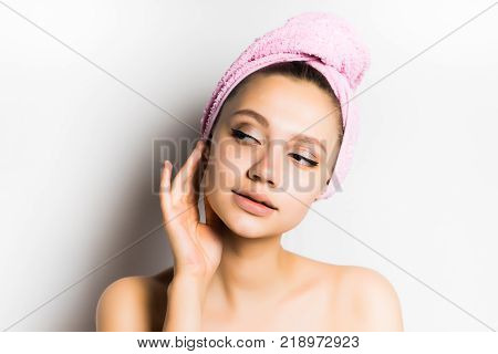 girl with a towel on her head raised her hand to her face