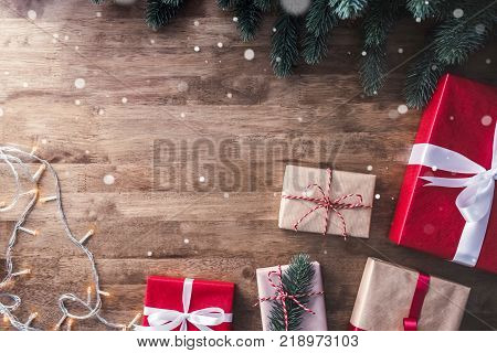 Christmas and new year background with gift boxes string light and green pine decorations on wood table background top view with coyp space