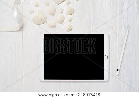 Mockup tablet computer and pencil on old wooden table with heart love, flatlay on a white wooden background, with place for your text. Flat lay, top view photo mock up.