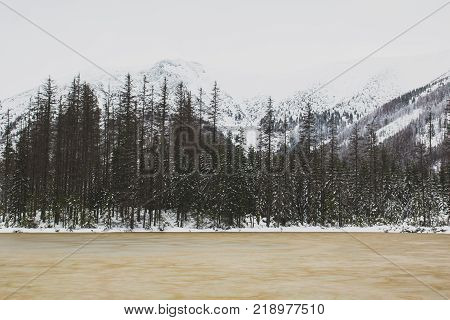 Frozen brown lake in winter in the mountains