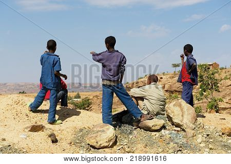 TIGRAY, ETHIOPIA - JANUARY 25, 2010: Unidentified Ethiopian teenager boys enjoy the rural view to the Debre Damo monastery area from a viewpoint in Tigray, Ethiopia.