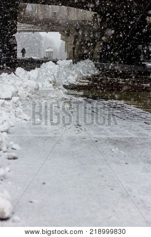 Sweep snow from road in winter. Part of winter frost sidewalk. Cold city street