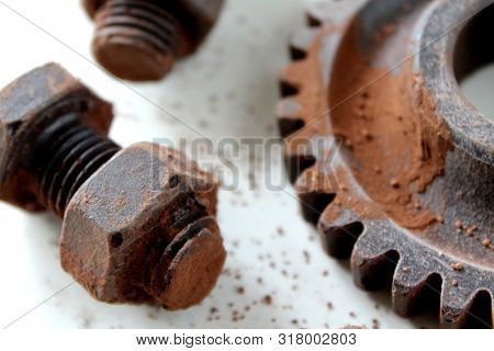 Rusty Bolts, Nuts And Gear Wheel Made Of Chocolate On White Background. Chocolate Chip Scattered On 