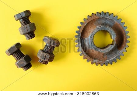 Rusty Bolts, Nuts And Gear Wheel Made Of Chocolate Isolated On Bright Yellow Background. Mechanic Ge