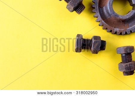 Rusty Bolts, Nuts And Gear Wheel Made Of Chocolate Isolated On Yellow Background. Mechanic Gearing B