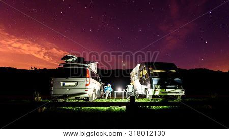 Campervans Are Parked On A Beach At Night Under Stars.