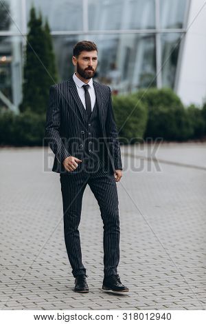 Confident Businessman. Confident Young Man In Full Suit Adjusting His Sleeve And Looking Away While 